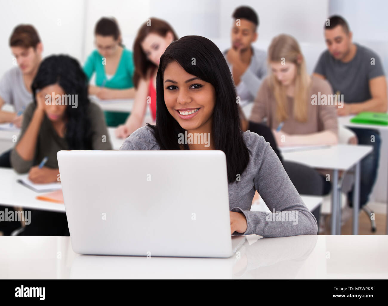 Portrait Of A Smiling Female Student Using Laptop Banque D'Images