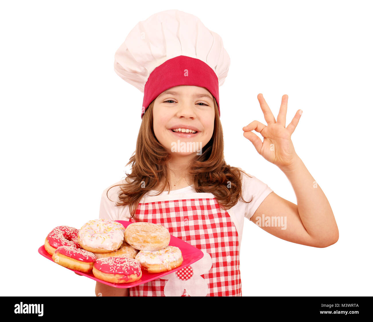 Happy little girl cook avec des beignets sucrés et ok part sign Banque D'Images