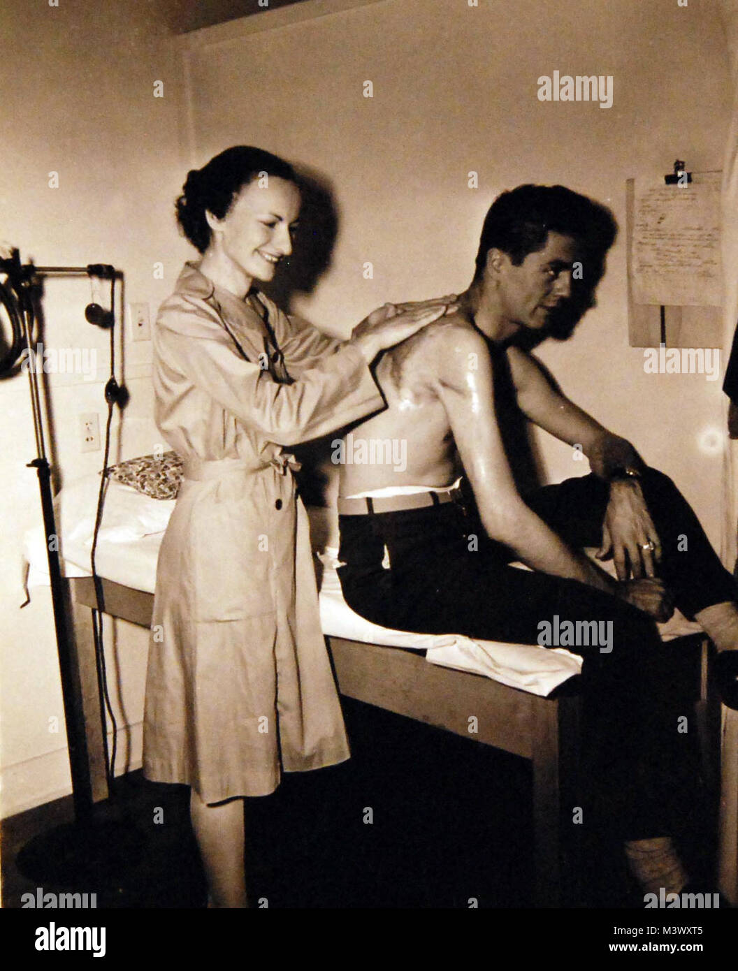 80-G-359962 : LES VAGUES au travail à l'Hôpital d'Oak Knoll, Oakland, Californie. PhM3c Marie Cerny, technicien de physiothérapie, de massages et d'une cicatrice de brûlure pour greffe de peau d'un patient. Photographie reçue le 4 mars 1946. Photographie de la Marine américaine officielle, aujourd'hui dans les collections des Archives nationales. (2017/12/13). 80-G-359962 o__27261766169 Banque D'Images