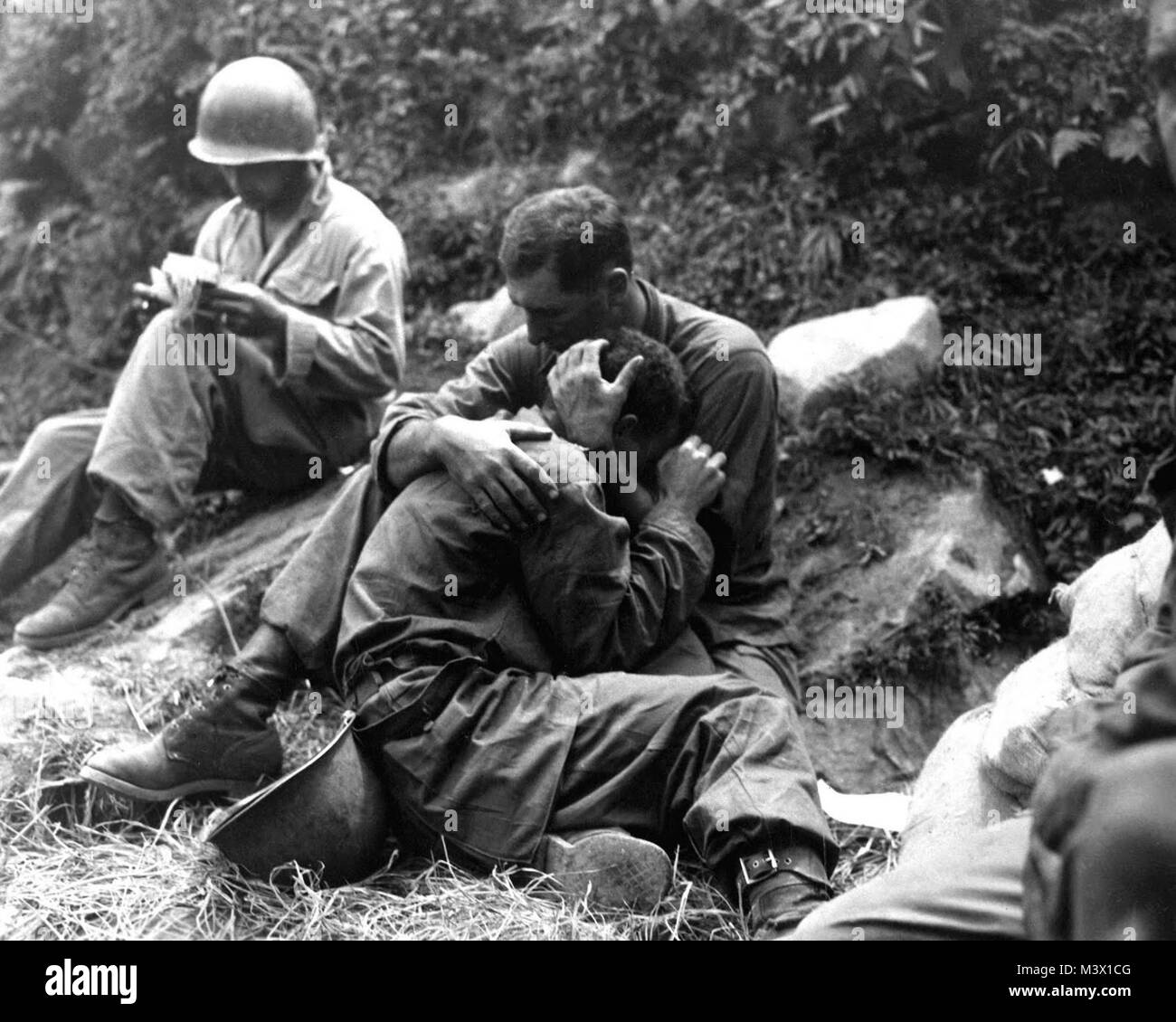 Description en français : un pauvre fantassin américain chagrin dont l'amie a été tué en action est réconforté par un autre soldat. Dans l'arrière-plan un remplit méthodiquement corpsman casualty tags, Haktong-ni, Corée. Le 28 août 1950. Sfc. Al Chang. (Armée) Centre des médias de la Corée de l'armée américaine de la guerre de Corée officielle vidéo en ligne Date28 août 1950 Sourcehttp www.flickr.com/photos/imcomkorea/2920380608/in/set-72157607808414225/ AuthorSfc ://. Al Chang, de l'armée américaine Autorisation (réutilisation de ce fichier) PD-Gov-Military KoreanWarFallenSoldier-Armée US1 par AirmanMagazine Banque D'Images