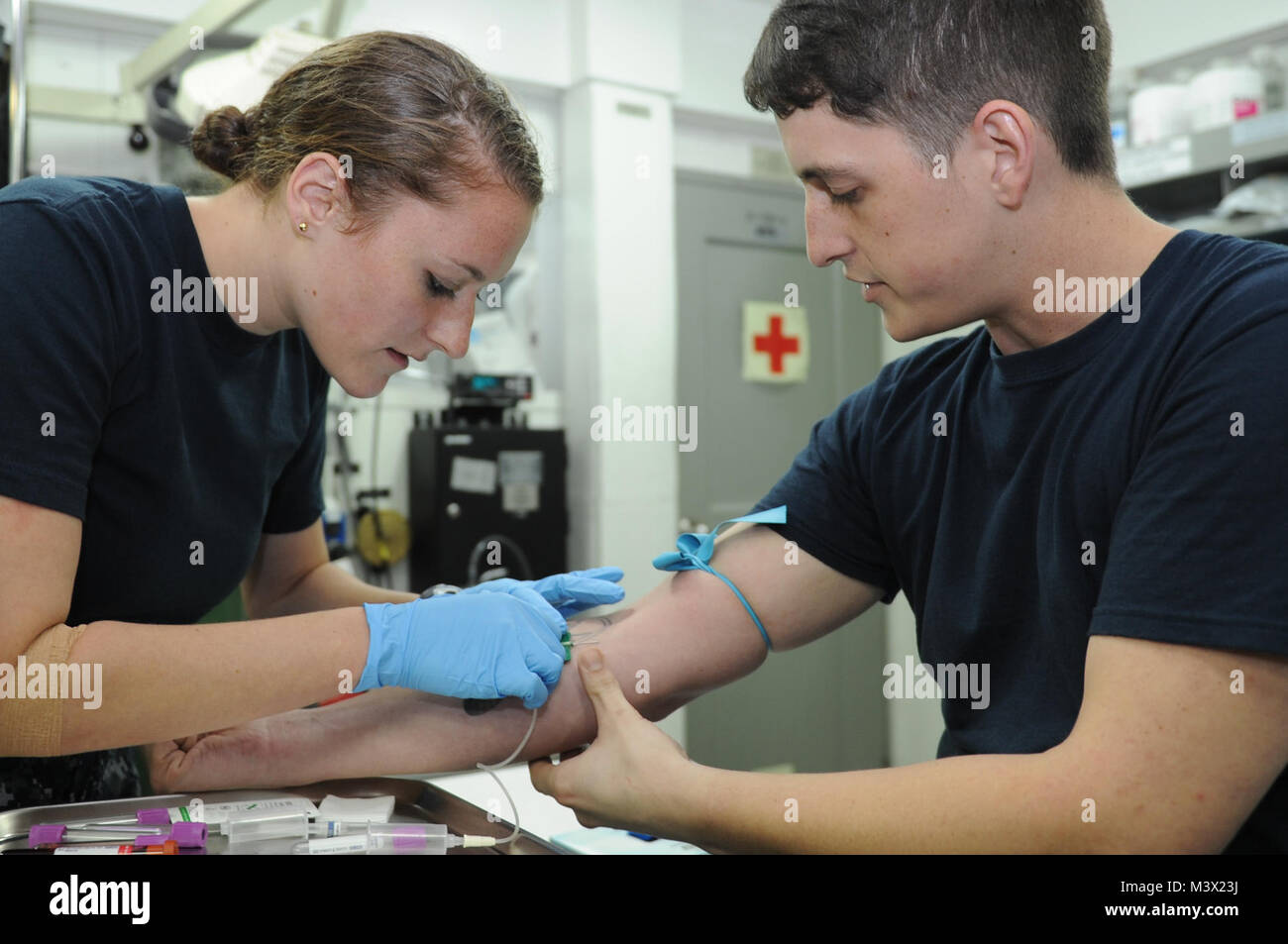 Golfe d'Oman (26 juin 2013) - L'Aspirant de 3 classe Katherine Baile, à gauche, de la Pennsylvania State University, attire le sang de l'hôpital Corpsman 3e classe David Johnson, de San Diego, à bord du porte-avions USS Nimitz (CVN 68). Un groupe d'intervention de Nimitz est déployé sur le 5e Flotte des États-Unis zone de responsabilité des opérations de sécurité maritime, les efforts de coopération en matière de sécurité dans le théâtre et missions d'appui pour l'opération Enduring Freedom. (U.S. Photo par marine Spécialiste de la communication de masse Seaman Apprentice Kelly M. Agee/ publié) 001 26 Juin 3 Lot de 8 Banque D'Images