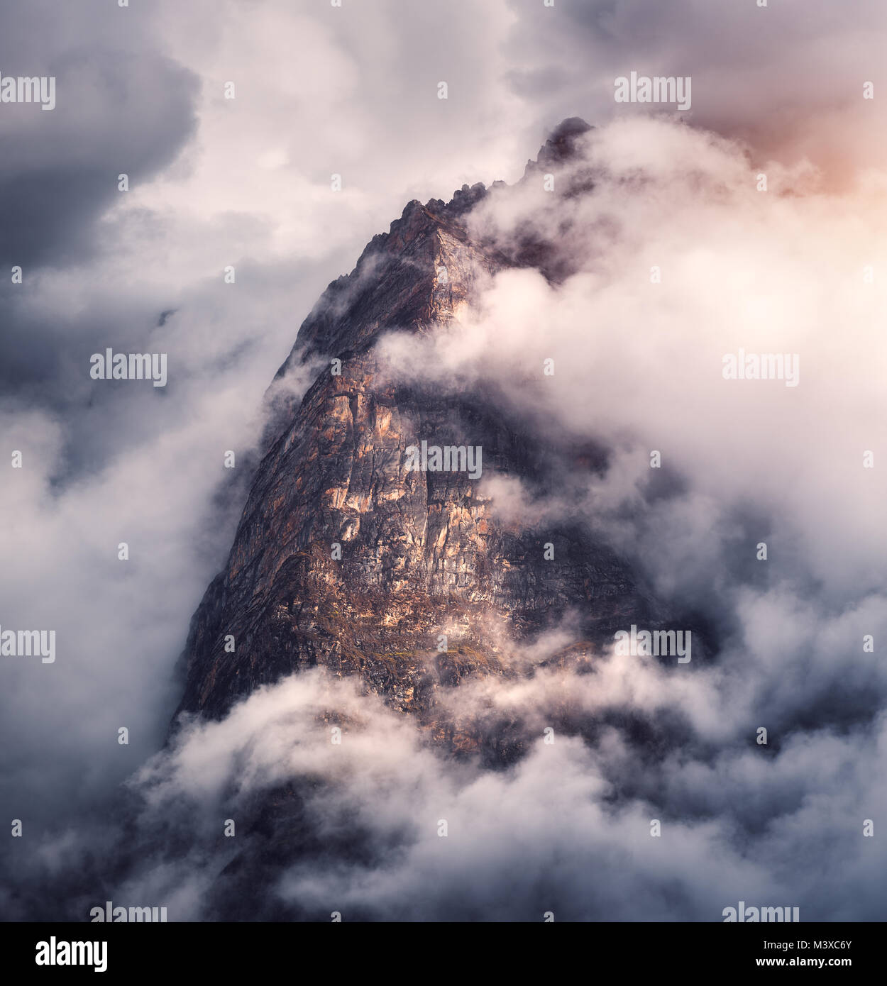 Montagnes majestueux dans les nuages ciel couvert en soirée au Népal. Paysage avec de belles hautes roches et dramatique ciel nuageux avec du soleil au coucher du soleil. Natu Banque D'Images