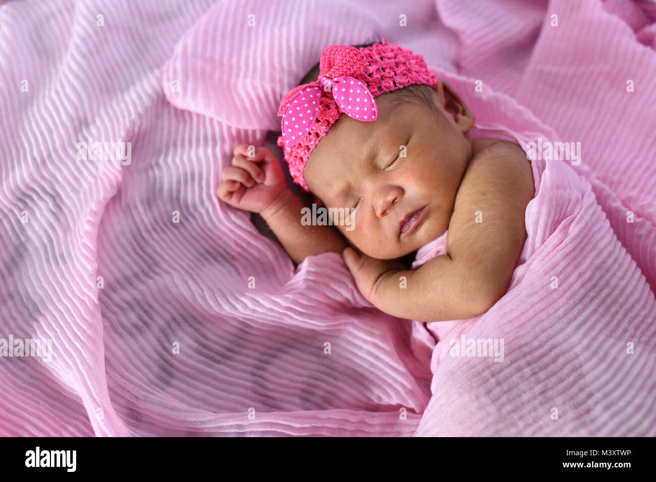 Asian newborn baby sleepin en tissu rose wearing headband. nouveau-né et la maternité concept Banque D'Images