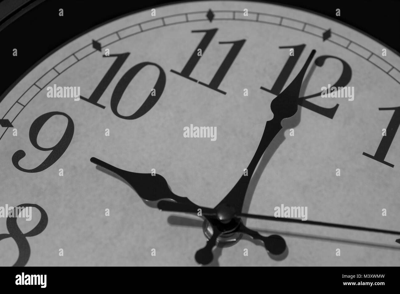 Gros plan sur les pointeurs d'une horloge marquant exactement neuf heures - le rendu noir et blanc. L'accent est mis sur l'heure et la minute de communication. Banque D'Images