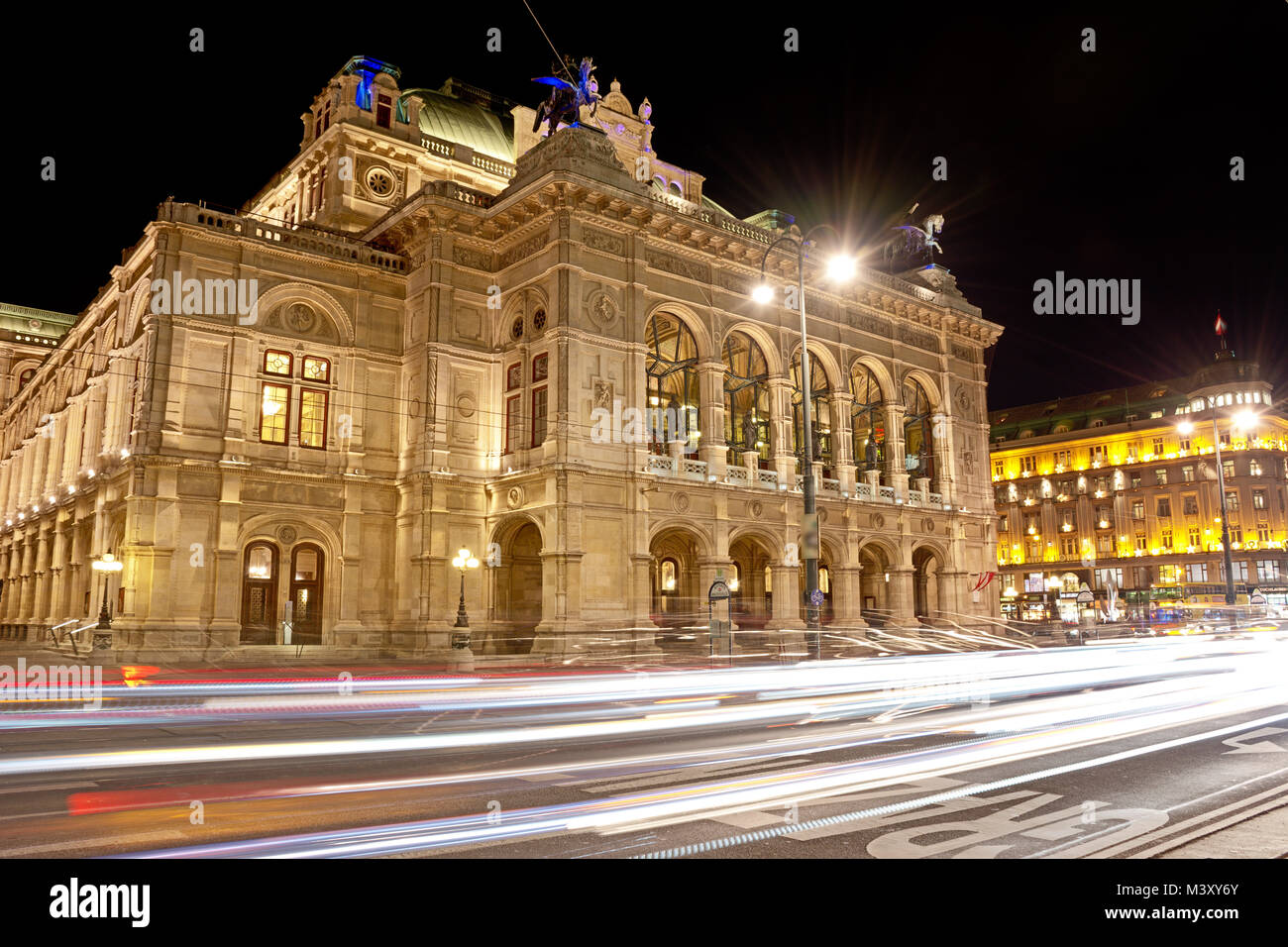 Opéra d'État de Vienne dans la nuit avec un feu de voiture sur l'anneau de sentiers de Vienne de la rue. Banque D'Images