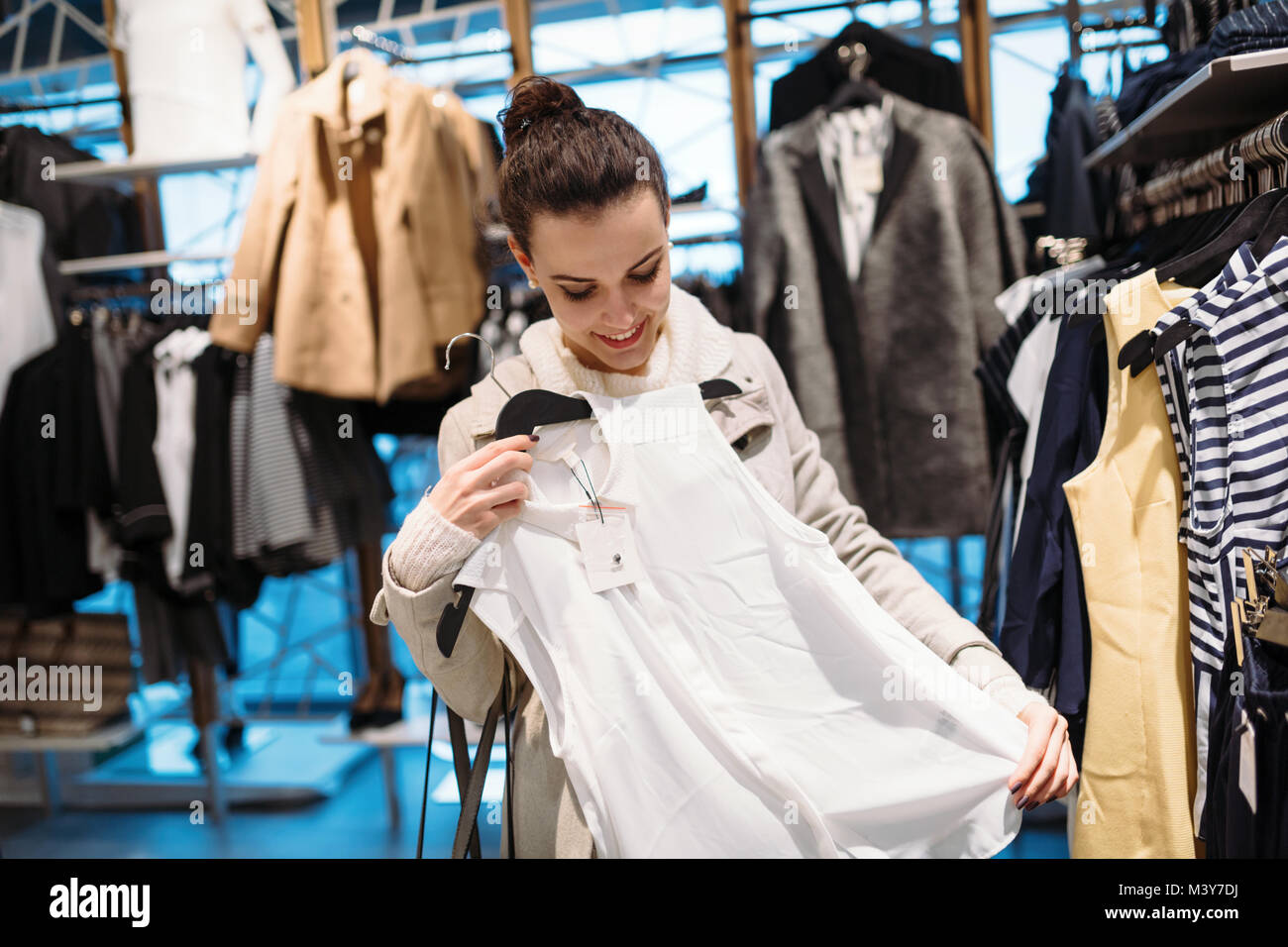 Young attractive woman buying clothes in mall Banque D'Images