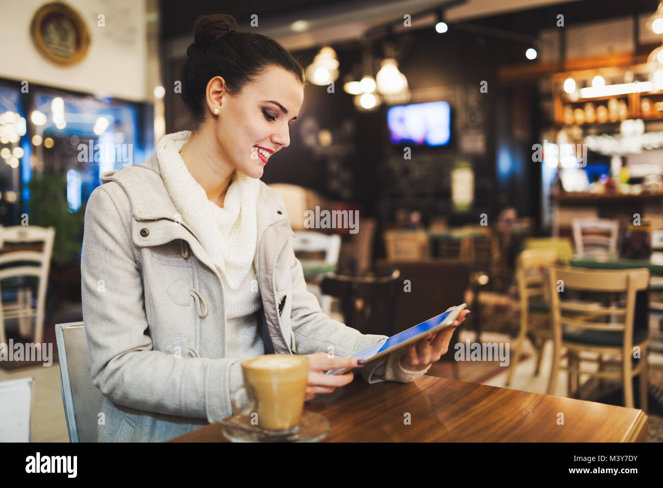 Attractive young woman using tablet in cafe Banque D'Images