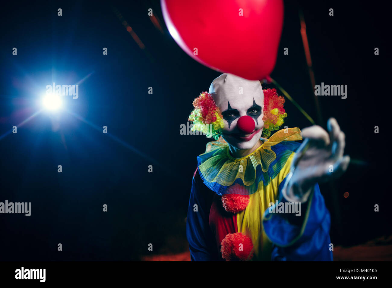 Photo de clown avec ballon rouge sur fond de lanterne de gravure Banque D'Images