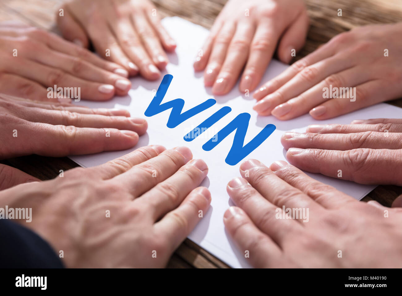 Les mains de toucher le papier blanc avec texte écrit Win Banque D'Images
