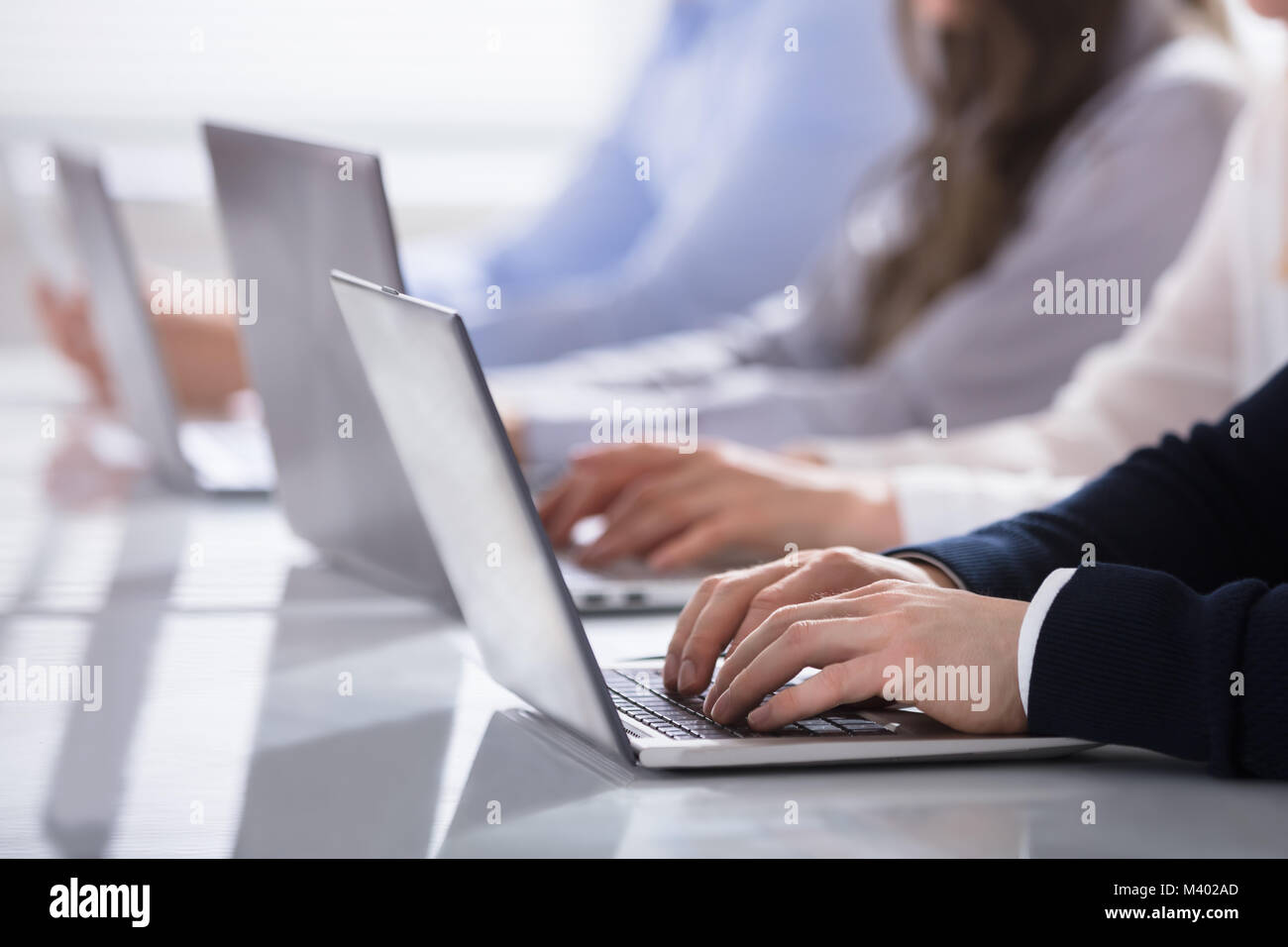 Close-up of a Businessman les mains sur le clavier de l'ordinateur portable sur Desk In Office Banque D'Images