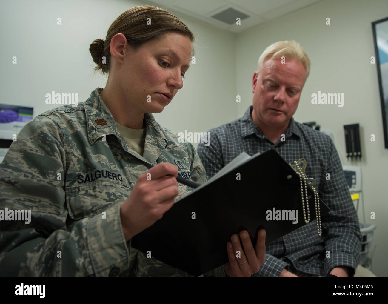 Le Major de l'US Air Force (Dr.) Jennifer Salguero 377Groupe médical, clinique de médecine familiale directeur médical, parle avec Jim Fisher, 377e Escadre de la Base aérienne spécialiste des affaires publiques, sur l'acupuncture combay au 377e Groupe médical des capacités à Albuquerque, N.M., 7 février. Bataille l'Acupuncture a été créée par le Dr Richard Niemtzow en service actif dans l'United States Air Force en 2001. (U.S. Photo de l'Armée de l'air par le sergent. J.D. Strong II) Banque D'Images