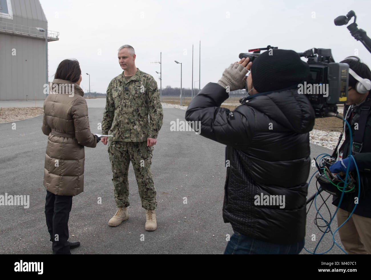 180207-N-GP524-0238 ÉGIDE À TERRE DE DÉFENSE ANTIMISSILE, Roumanie (fév. 7, 2018). Mark Fegley, centre, commandant de l'Égide à terre de défense antimissile (AAMDS) Roumanie, est interviewé par les médias japonais Asahi TV anchor Tomoko Nagano, gauche, au cours d'un service médias s'embarquer. L'installation de soutien naval et Deveselu AAMDS Roumanie sont situés dans la base militaire roumaine 99e et jouer un rôle clé dans la défense antimissile balistique en Europe orientale. (U.S. Photo par marine Spécialiste de la communication de masse 2e classe Bill Dodge/libérés) Banque D'Images