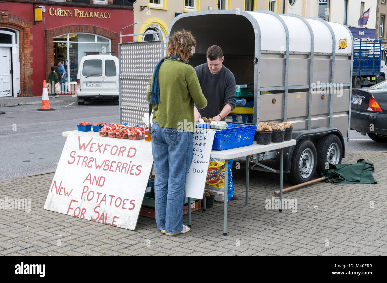 Un client qui achète des produits frais locaux à partir d'un étal du marché alimentaire à Bantry, Irlande du Sud Banque D'Images