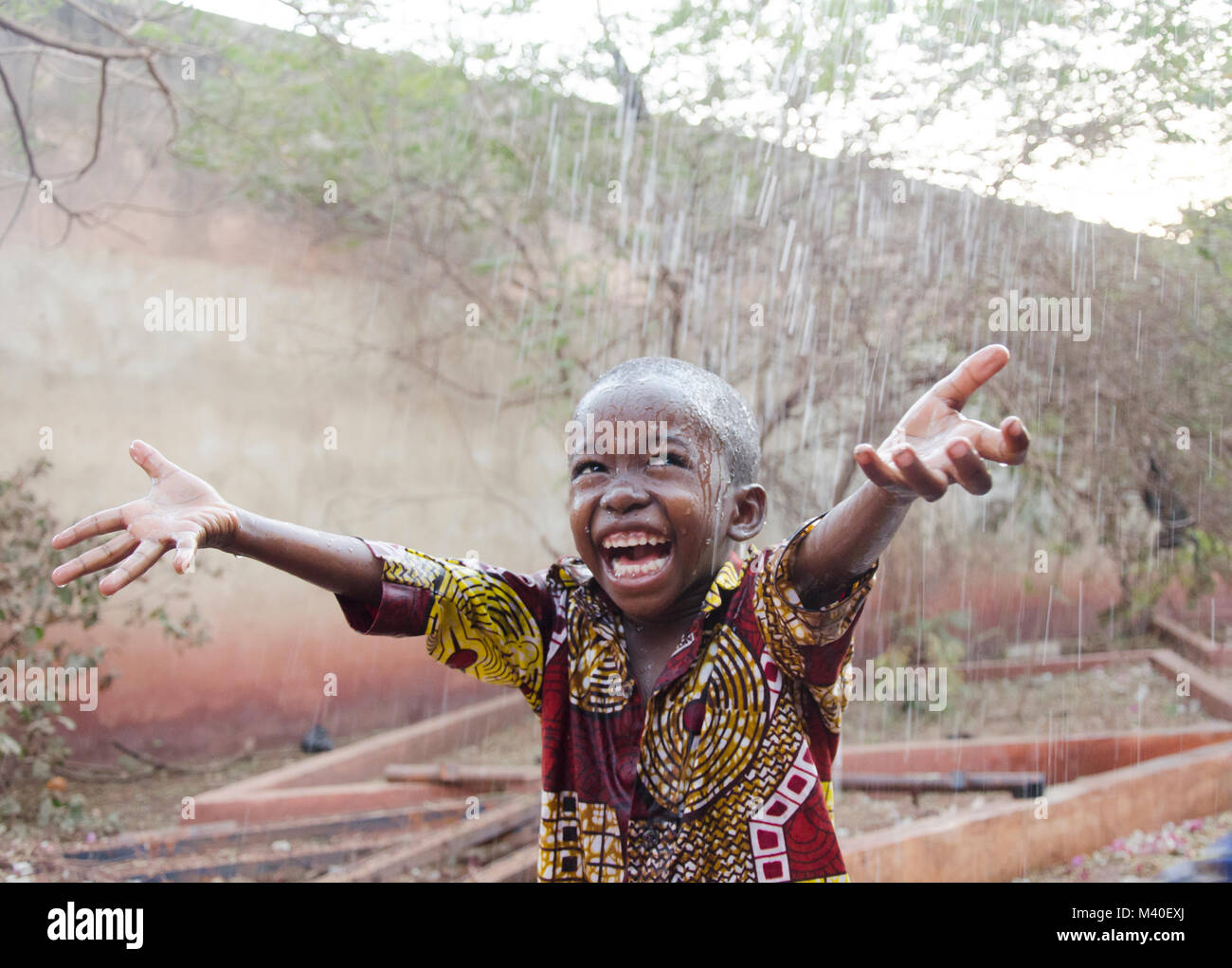 Gentil petit garçon africain sous la pluie au Mali (Afrique) Banque D'Images