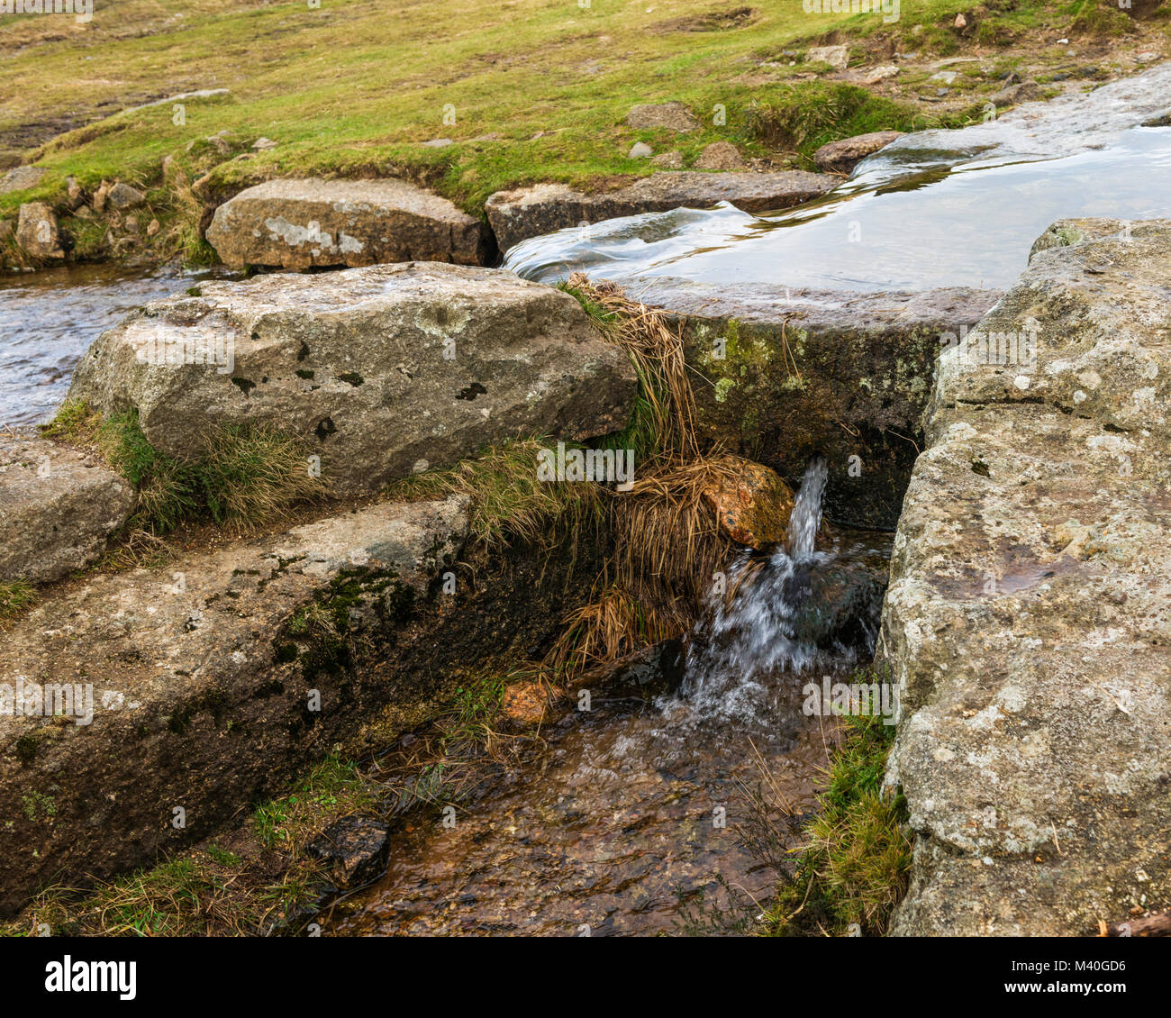 Bullseye 'pierre' sur Grimstone et Sortridge Leat, Parc National de Dartmoor. Le trou dans la pierre régule le débit d'eau dans un canal latéral. Banque D'Images