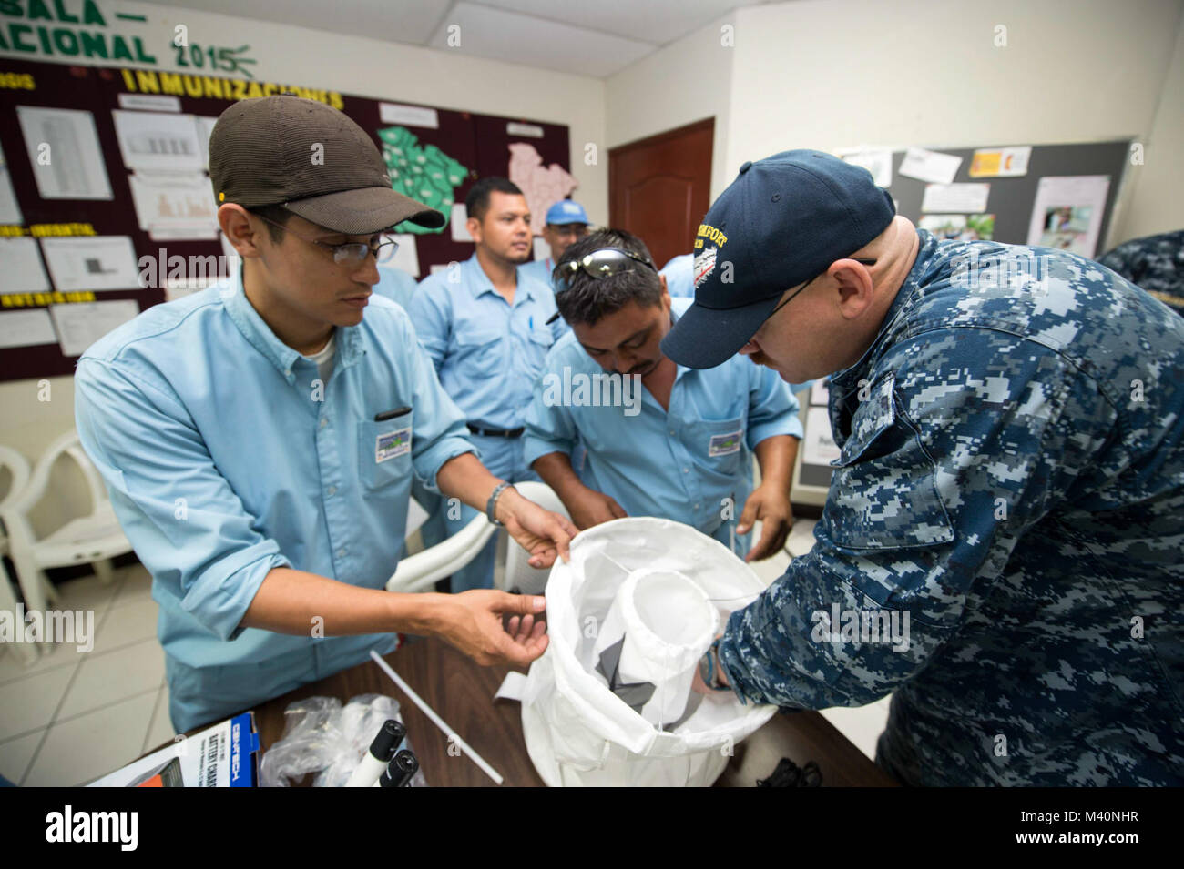 150622-N-XQ474-111 ACAJUTLA, El Salvador (22 juin 2015) Hospital Corpsman 1re classe Luc Peet, affecté à l'unité de médecine préventive de l'environnement marine-2 à Norfolk en Virginie, discute avec des pièges à moustiques vecteurs experts base salvadorienne au cours d'un échange d'experts en la matière à l'appui de la promesse continue 2015. Promesse continue est un U.S. Southern Command-parrainé et U.S. Naval Forces Southern Command/U.S. 4ème flotte-déploiement effectué pour mener des opérations civiles et militaires, y compris l'aide humanitaire civile-, expert en la matière d'échanges, de soins médicaux, dentaires, vétérinaires et de l'ingénierie matérielle Banque D'Images