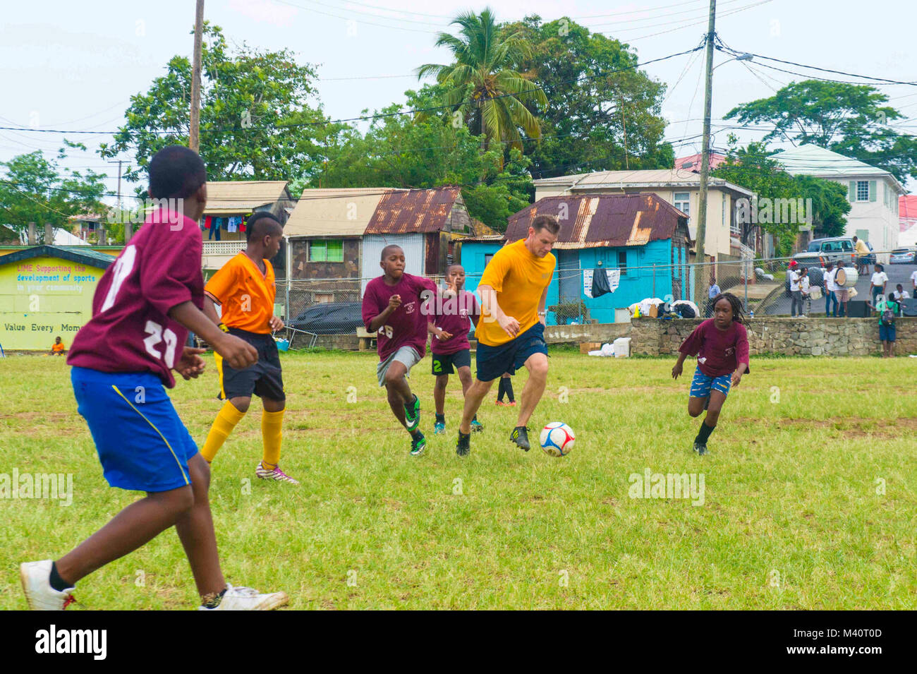 150730-N-YM856-221 ROSEAU, Dominique (30 juillet 2015) Le Cmdr. Bradley Killenbeck, originaire de Spencer Court, N.Y., attribué à Naval Medical Center Portsmouth en Virginie, joue au soccer avec enfants dominicains au cours d'un événement de relations communautaires à l'appui de la promesse continue 2015. Promesse continue est un U.S. Southern Command-parrainé et U.S. Naval Forces Southern Command/U.S. 4ème flotte-déploiement effectué pour mener des opérations civiles et militaires, y compris l'aide humanitaire civile-, expert en la matière d'échanges, de soins médicaux, dentaires, vétérinaires et du soutien technique et la réaction aux catastrophes au partenaire n Banque D'Images