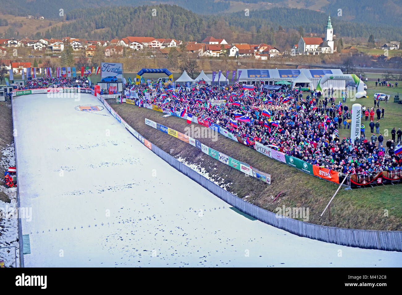 Outran de Saut à Ski Hill et acclamer audiance du ventilateur pendant la Coupe du Monde pour dames en Ljubno ob Savinji (ville de l'arrière-plan). La Slovénie. Banque D'Images
