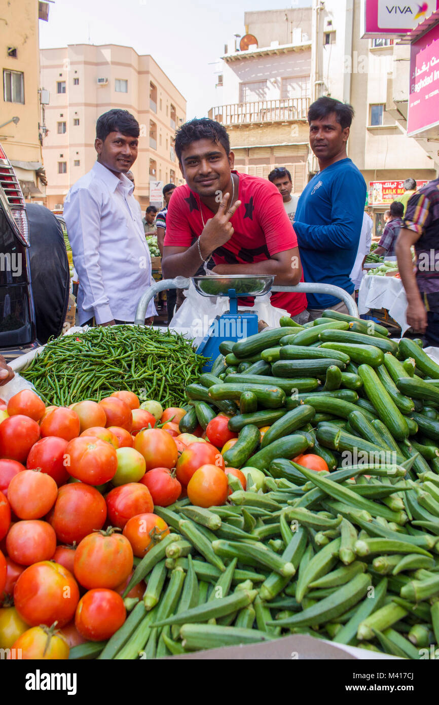 Vendeur de légumes en face de son stand à un marché en plein air à Manama, Bahreïn, Banque D'Images