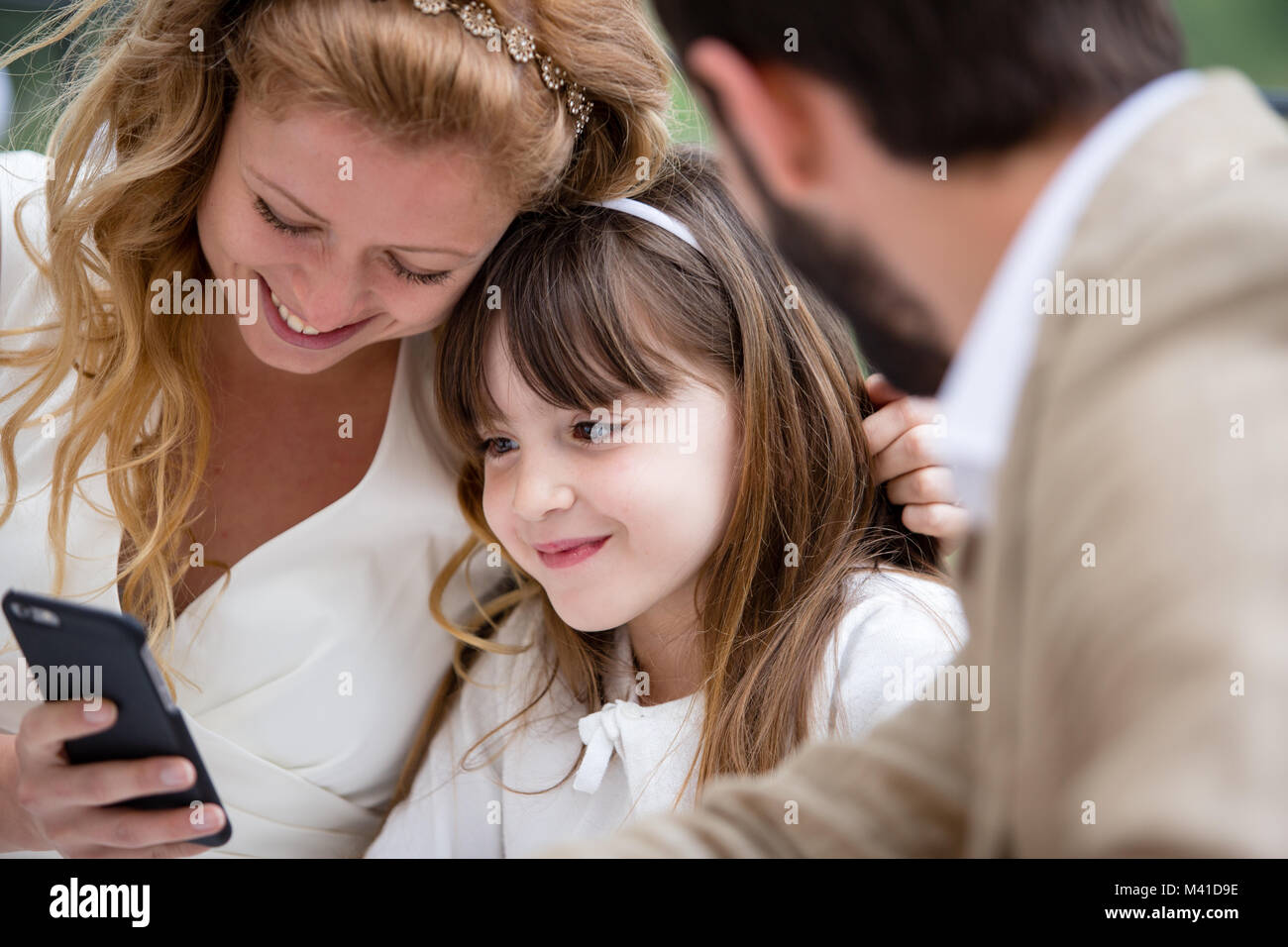 Bridge et le marié avec sa fille looking at smartphone Banque D'Images