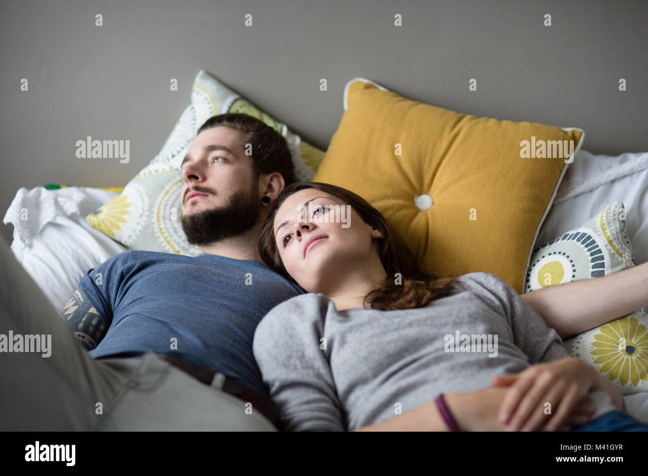 Young couple relaxing in bed Banque D'Images