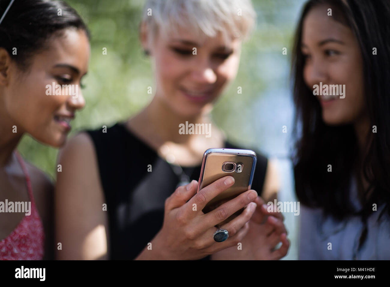 Close-up of friends looking at smartphone Banque D'Images