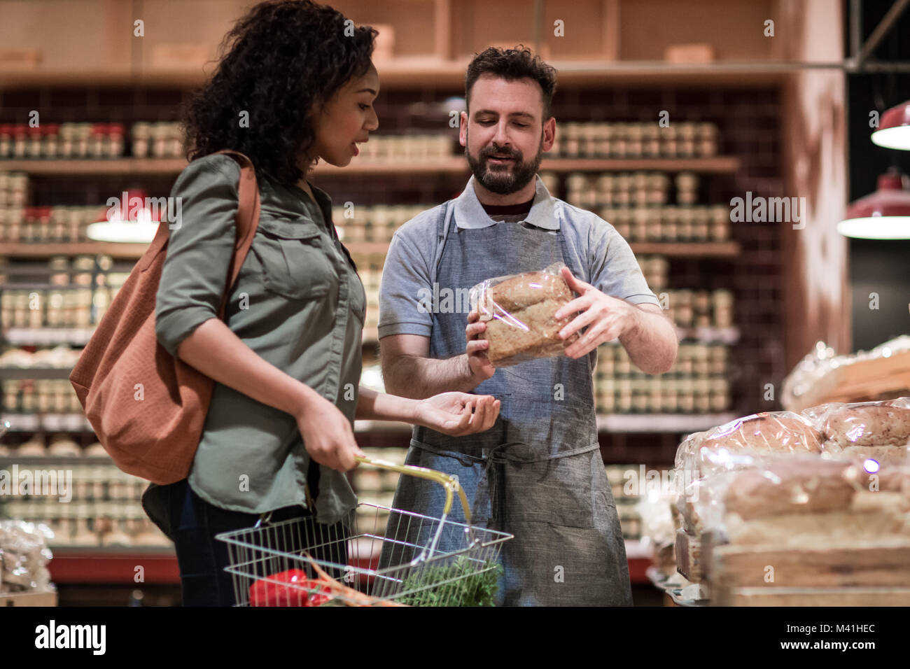 Baker helping customer in grocery store Banque D'Images