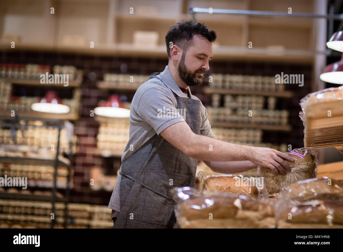 Boulangerie Baker à l'ensemencement des étagères et à la recherche à l'appareil photo Banque D'Images