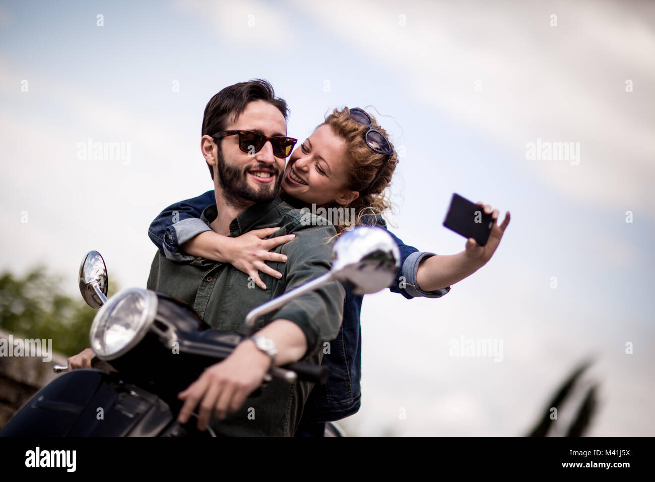 Jeune couple en moto en tenant un selfies Banque D'Images