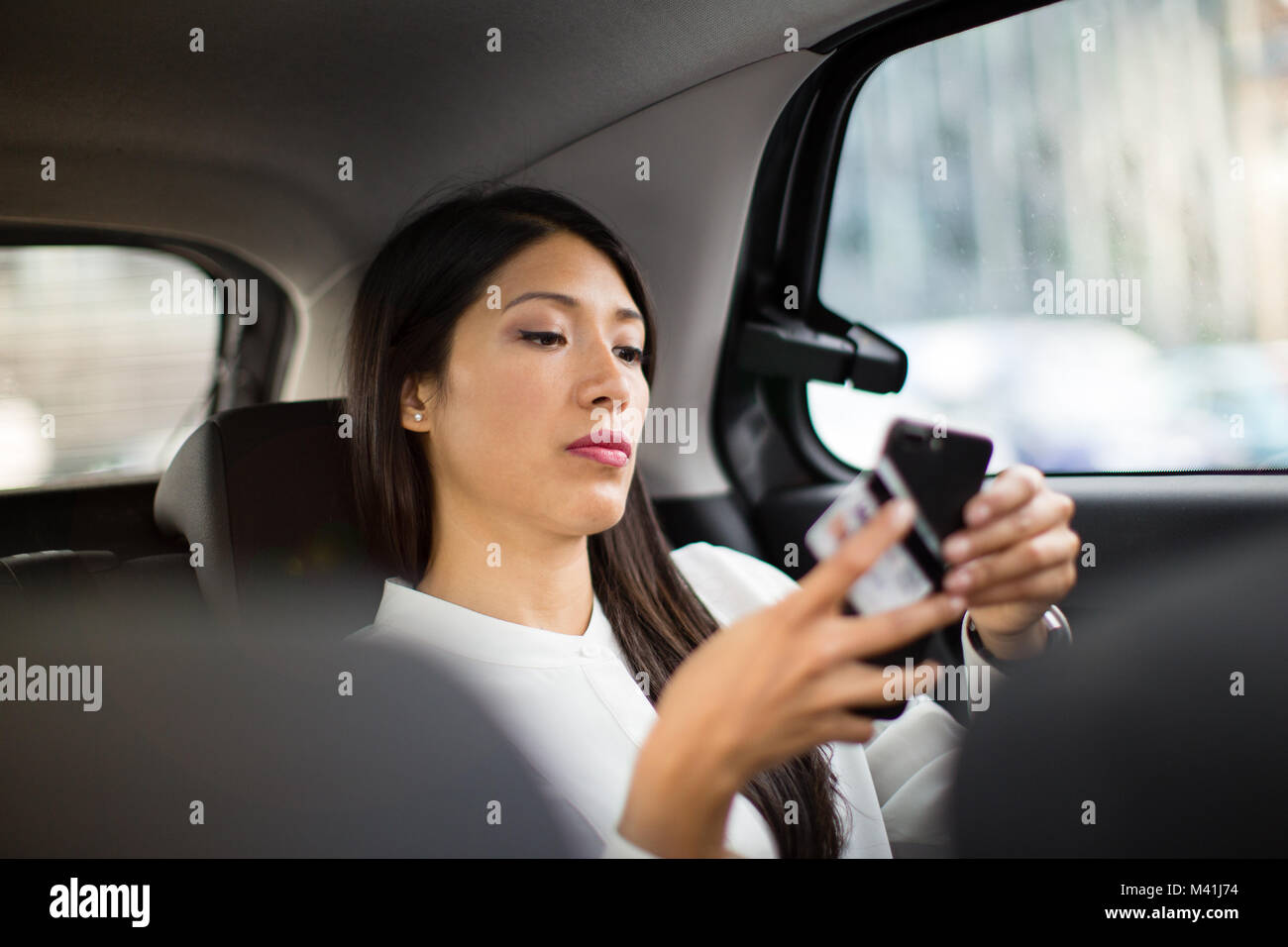 Businesswoman payer via l'app pour taxi cab ride Banque D'Images