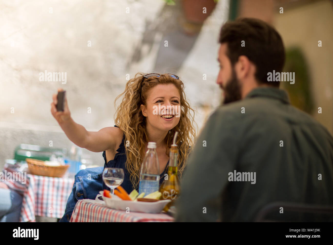 Jeune couple de manger en plein air en prenant un selfies Banque D'Images
