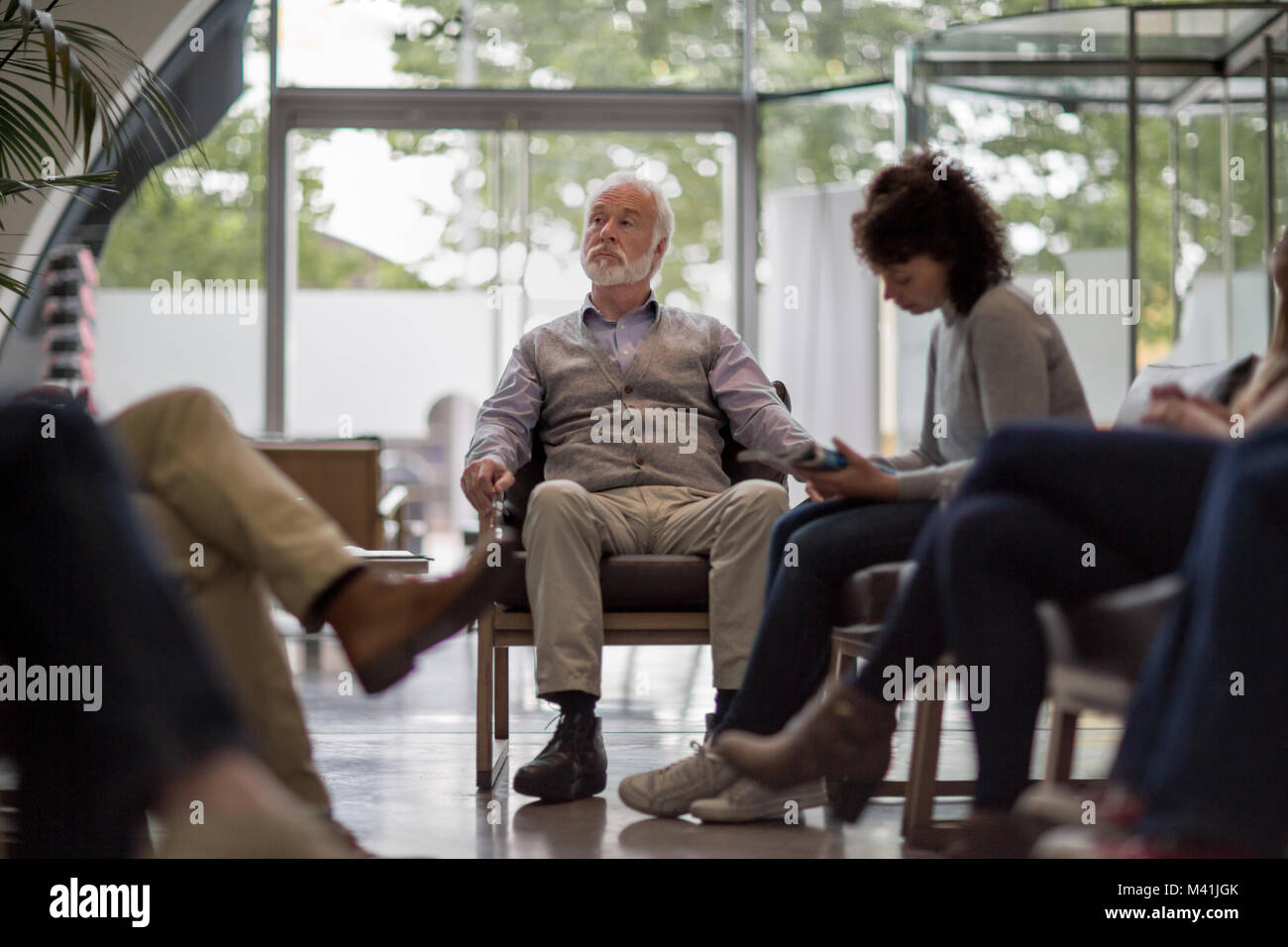 Senior Male en attente dans une salle d'attente hôpital bondé Banque D'Images