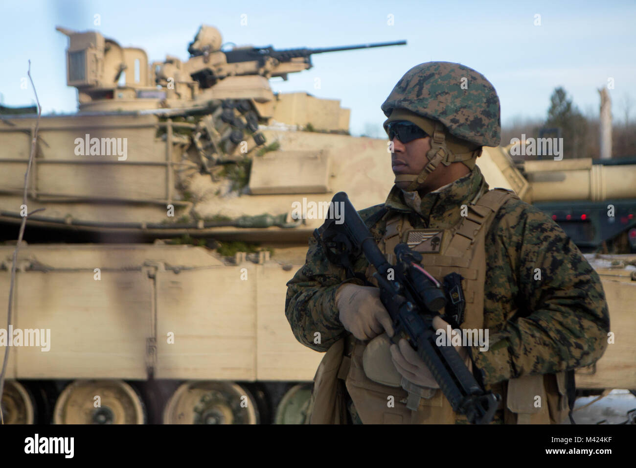 Réserver les Cpl. Abdrahman Nasr, un chef d'équipe avec la société F, 4e Bataillon, 4e Division de marines, fournit la sécurité du périmètre alors qu'un véhicule de dépannage M88 est le plein, lors de l'exercice l'hiver 2018, près du camp de l'Arctique, Michigan, le 10 février 2018. Réserver marines passent deux semaines chaque année des capacités de leurs capacités à un exercice annuel d'entraînement. Cette année, le Camp Lejeune, en Caroline du Nord, d'après la compagnie du réservoir est en train de profiter de l'ombre du Camp d'entraînement robuste pour tester leur offensive, défensive et de capacités de manœuvre dans un environnement froid austère. Banque D'Images