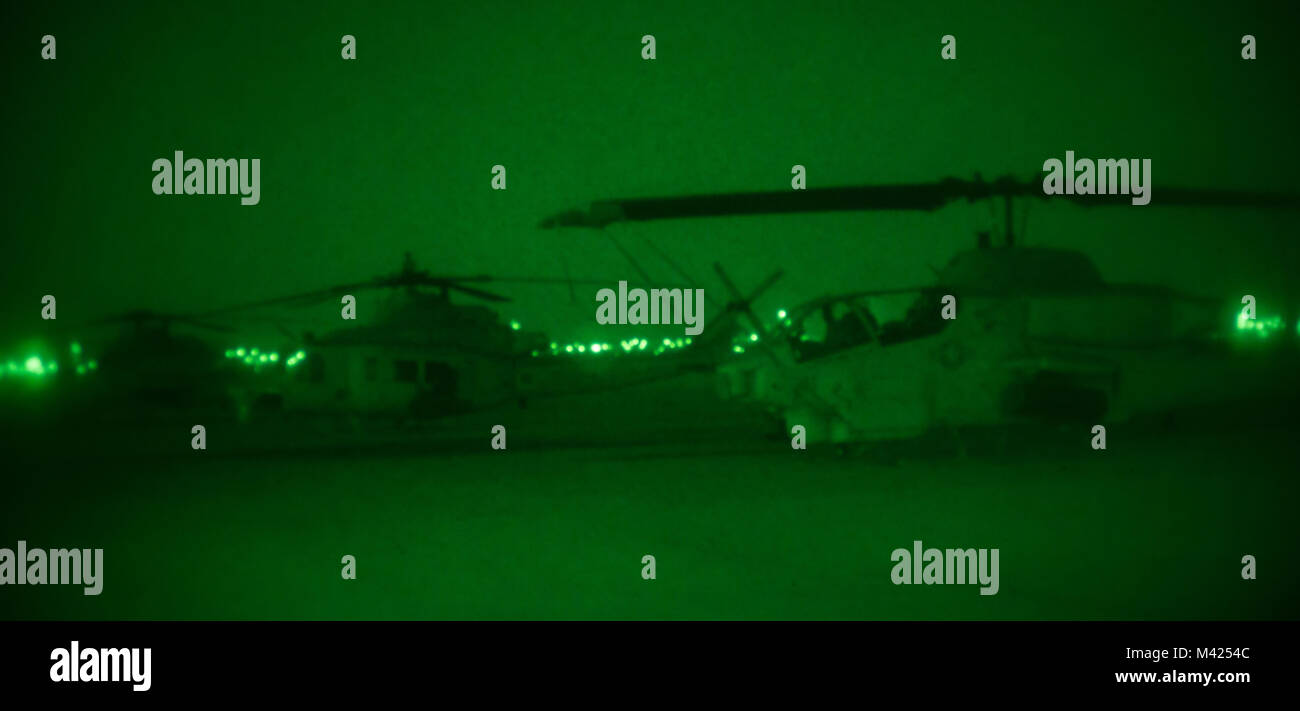 Un AH-1W Super Cobra, attribué à Marine Test et d'évaluation (Escadron VMX), un siège avec deux hélicoptères UH-1Y Venom sur la ligne de vol à bord de Marine Corps Air Station Yuma (Arizona), le 23 janvier 2018. Le Super Cobra agit comme le close air support de plates-formes marines sous le feu dans la masse d'Air Maritime Task Force (MAGTF). (U.S. Marine Corps photo prise par le Cpl. Isaac Martinez) Banque D'Images