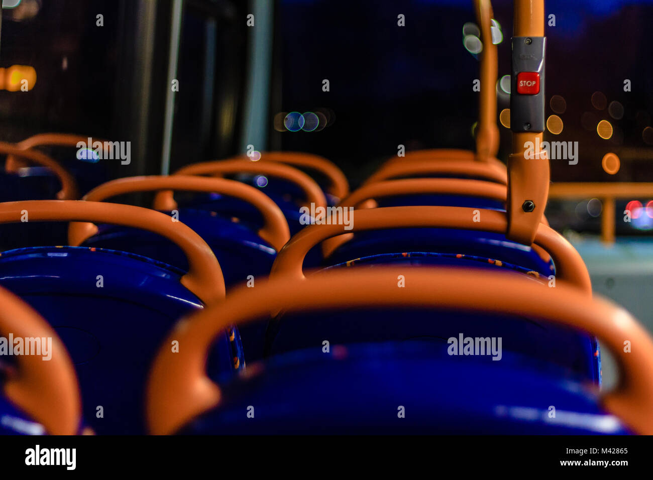 Intérieur du bus typiquement britannique avec un coin salon et un bouton d'arrêt rouge la nuit, Devon, UK. Feb 2018. Banque D'Images