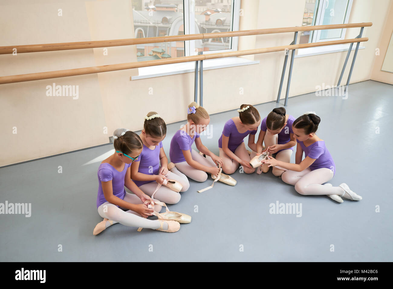 Six petits filles de ballet sur le sol. Groupe de jeunes jolies ballerines  en justaucorps similaire pour la préparation des leçons de danse Photo  Stock - Alamy