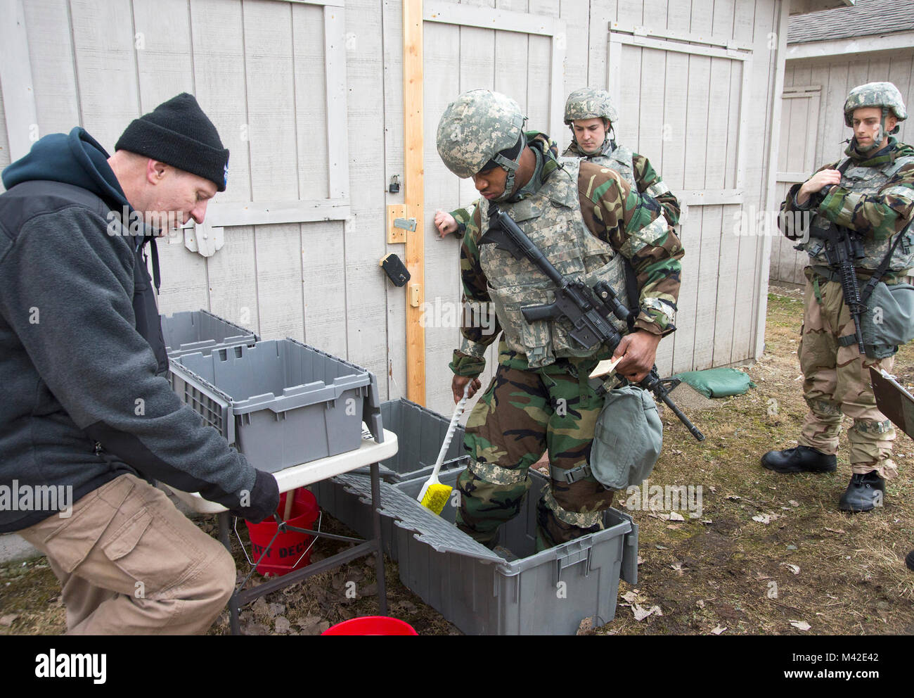 Dennis Meyers, 788th escadron de Génie Civil Centre de gestion des urgences, à gauche, les trains d'aviateurs sur les techniques de décontamination chimique au cours d'un exercice sur la base aérienne de Wright-Patterson, Ohio, le 31 janvier 2018. Le personnel opérant dans un environnement contaminé doit passer par la décontamination avant de revenir à un "nettoyage". (U.S. Air Force Banque D'Images