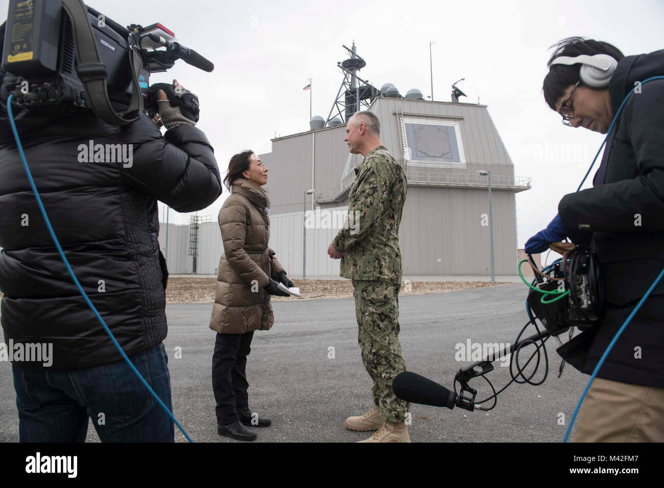 À TERRE DE DÉFENSE ANTIMISSILE, Roumanie (fév. 7, 2018). Mark Fegley, centre droit, commandant de l'Égide à terre de défense antimissile (AAMDS) Roumanie, est interviewé par les médias japonais Asahi TV anchor Tomoko Nagano, au centre gauche, au cours d'un service médias s'embarquer. L'installation de soutien naval et Deveselu AAMDS Roumanie sont situés dans la base militaire roumaine 99e et jouer un rôle clé dans la défense antimissile balistique en Europe orientale. (U.S. Navy Banque D'Images