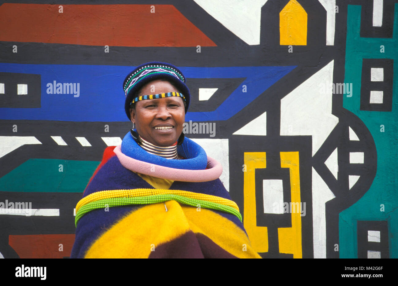 L'Afrique du Sud. Ndebele Mapoch Village, près de Pretoria. peintures murales traditionnelles de tribu Ndebele. Femme avec des vêtements traditionnels. Banque D'Images