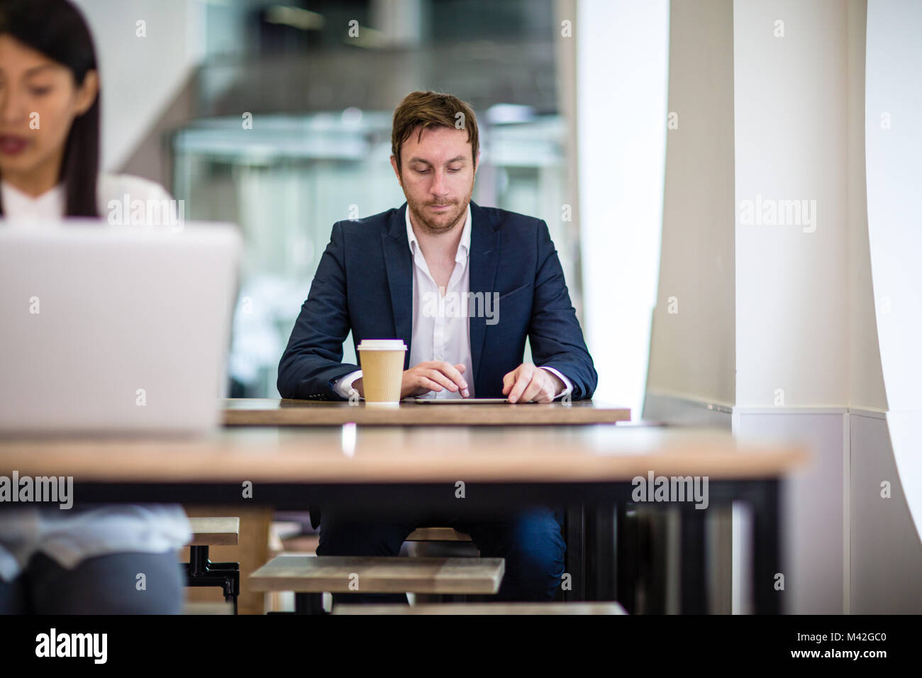 Businessman dans un café en lisant un digital tablet Banque D'Images