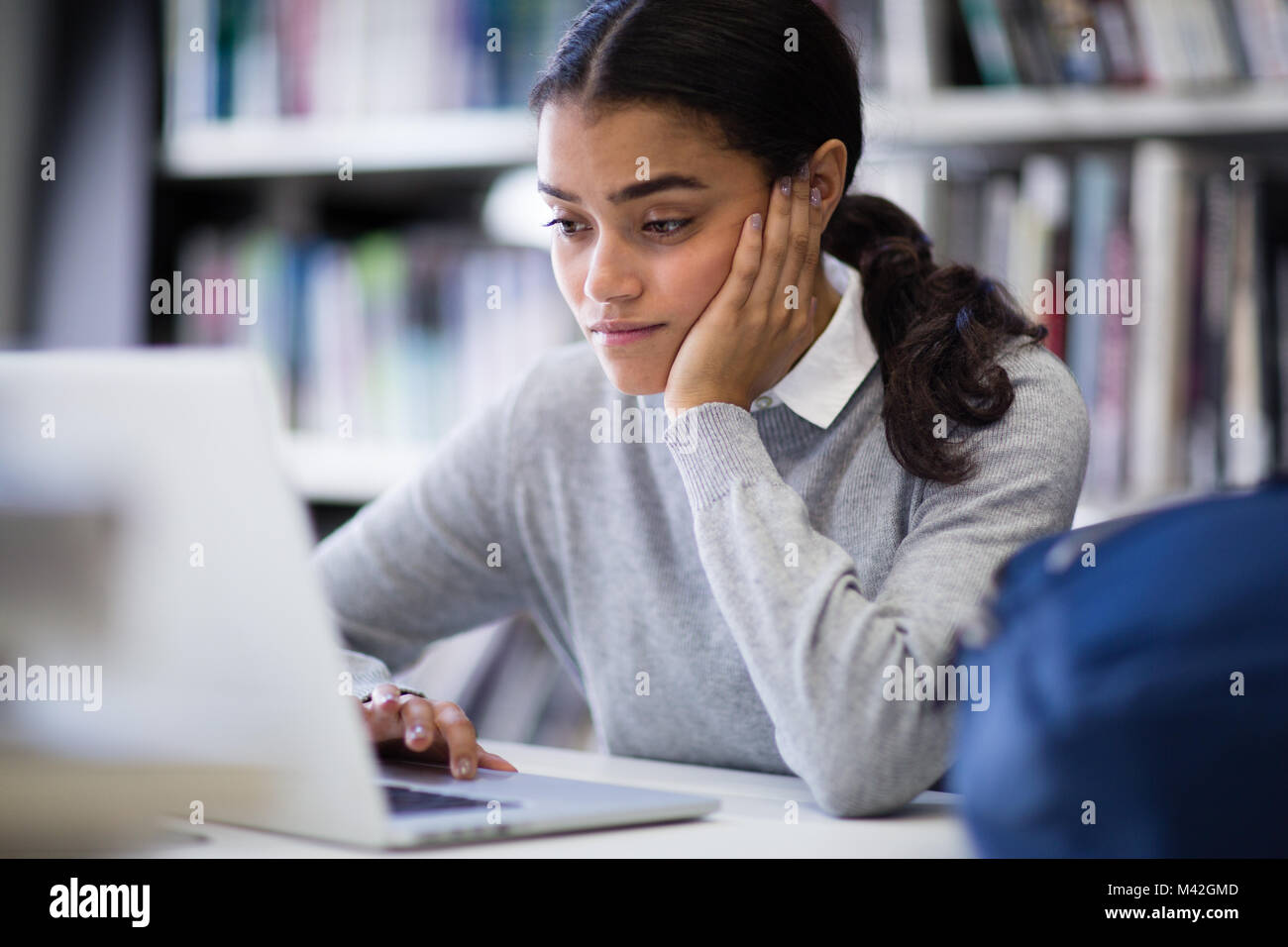 Student working on laptop in library Banque D'Images