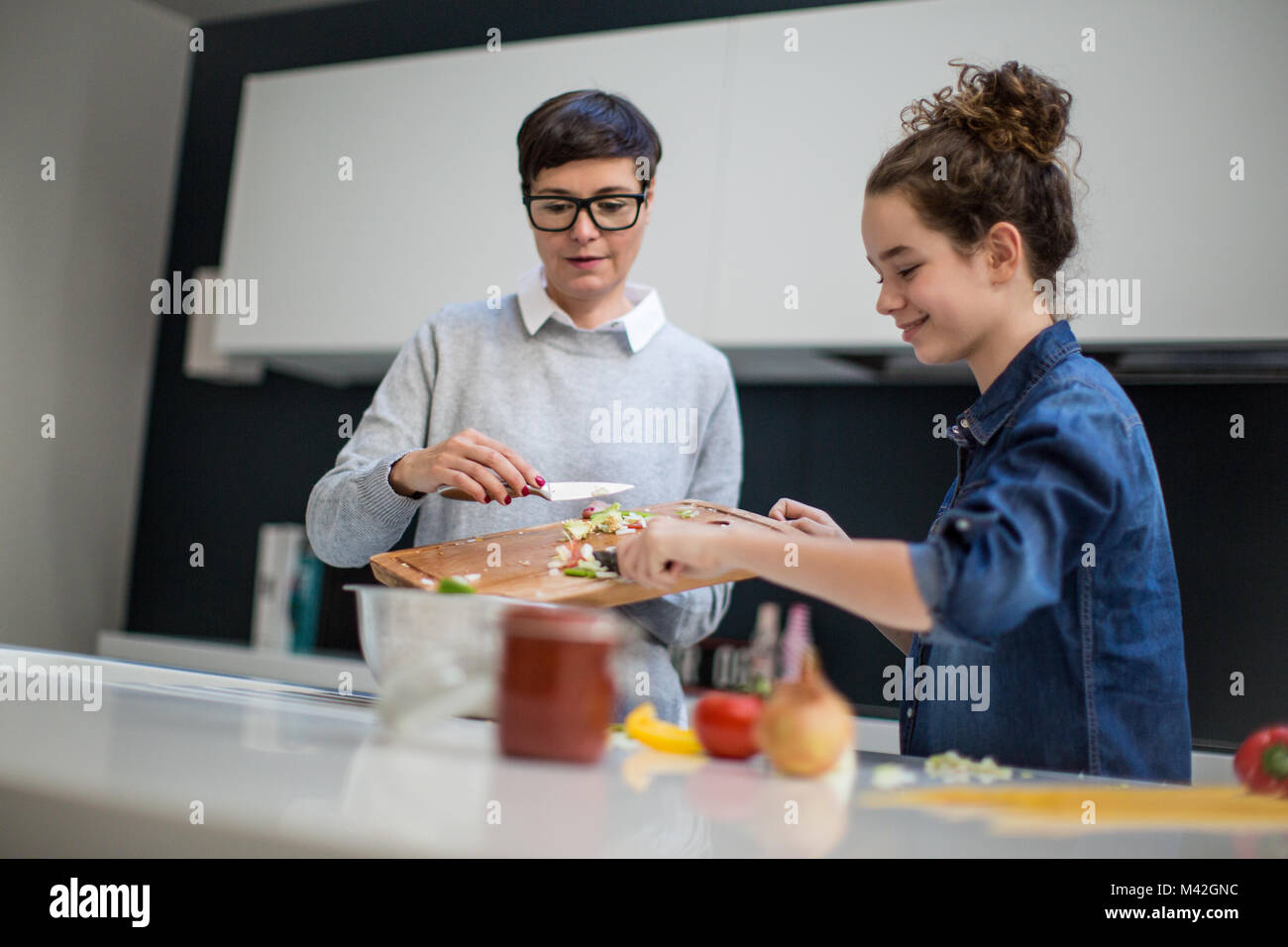 Mère et fille adolescente cooking together Banque D'Images