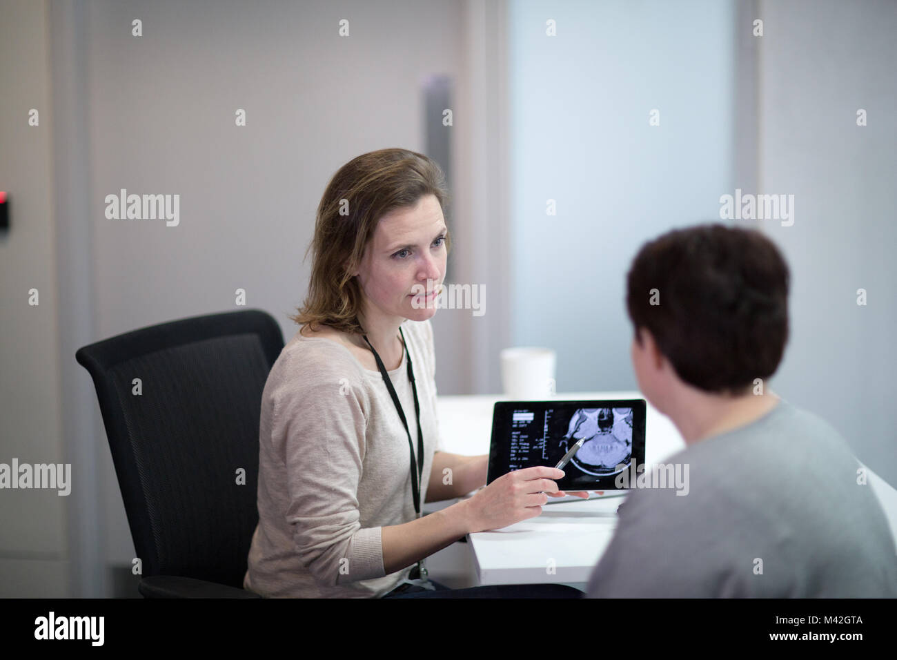 Femme médecin expliquant les résultats de scan au patient Banque D'Images