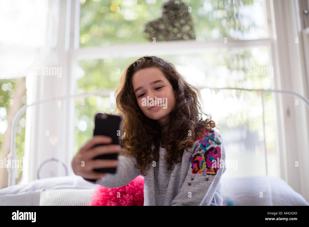 Adolescent dans la chambre en tenant un selfies Banque D'Images