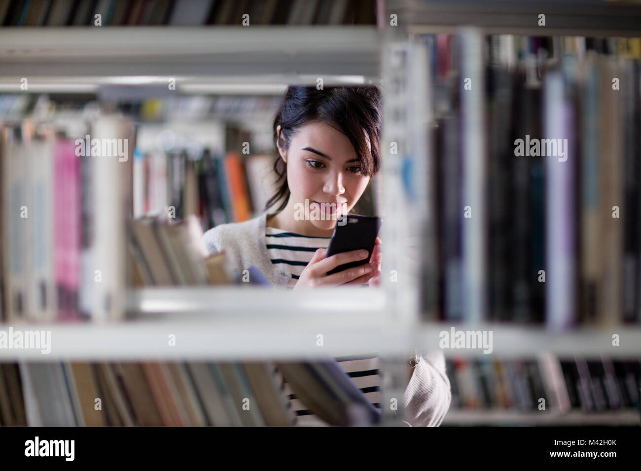 L'aide aux étudiants dans la bibliothèque du smartphone Banque D'Images