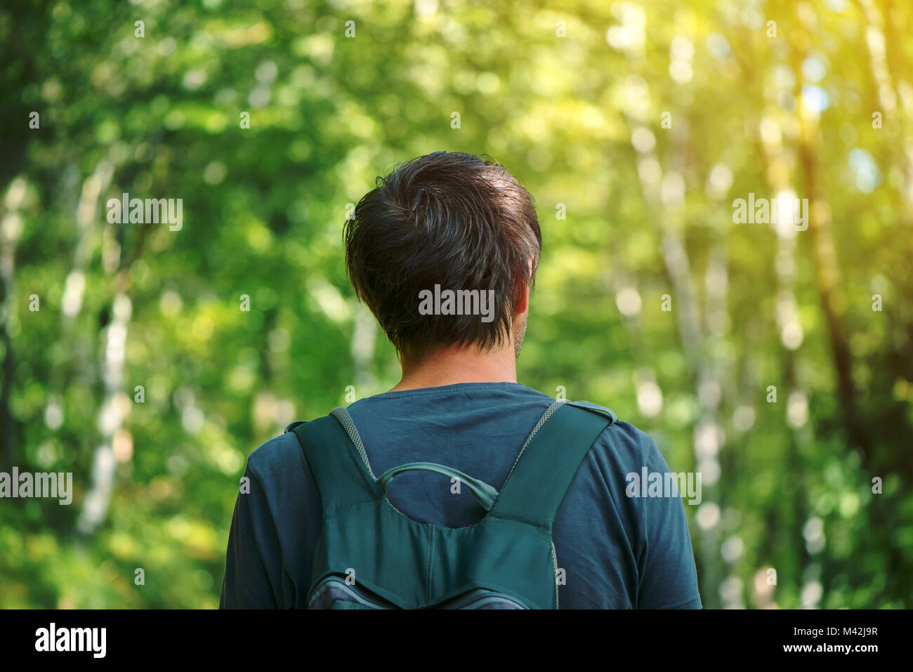 Vue arrière du sac à dos avec l'homme de race blanche adultes bénéficiant d'une promenade dans le parc aux beaux après-midi d'été. Bonne hygiène de vie, des loisirs et de la nature aimer Banque D'Images