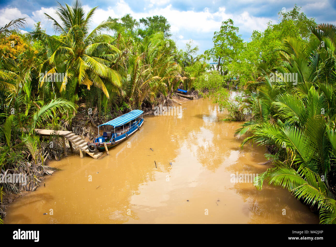 Cannal d'eau avec des bateaux dans le delta du Mékong, Vietnam, Ben Tre. Banque D'Images