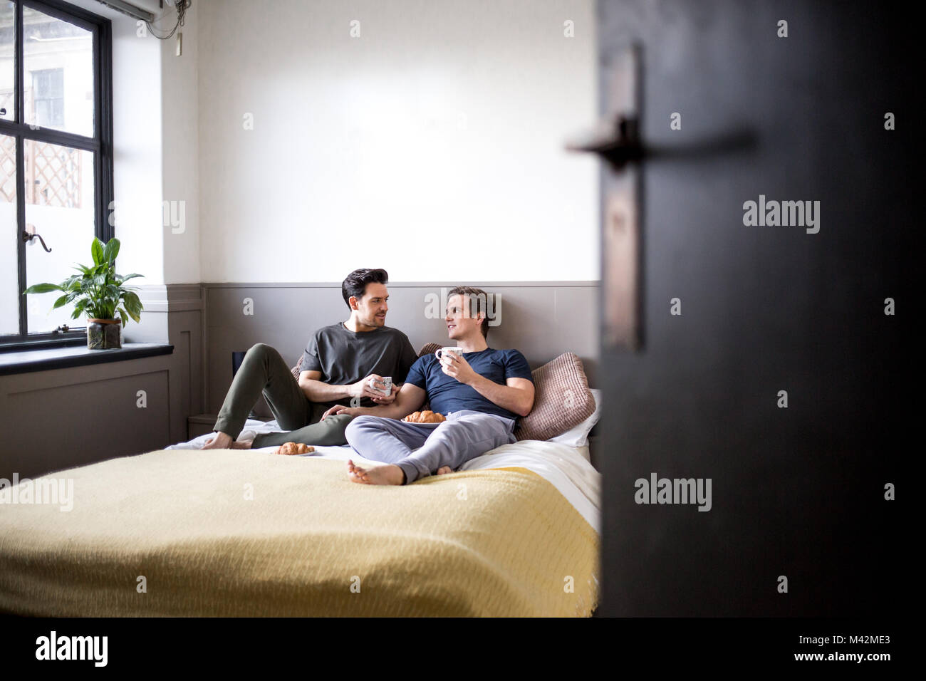 Gay couple relaxing bedroom Banque de photographies et d'images à haute  résolution - Alamy