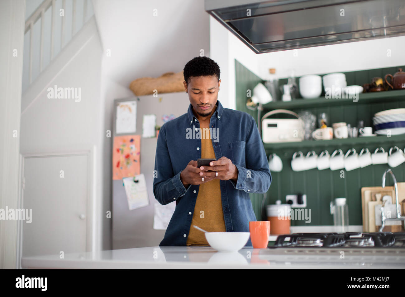 African American male contrôle de téléphone dans la matinée Banque D'Images