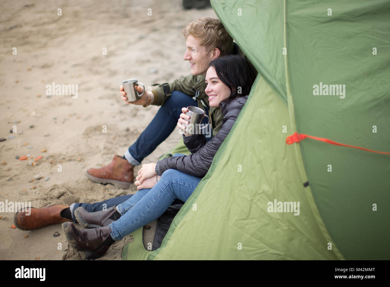 Jeune couple camping sur la plage à l'automne Banque D'Images